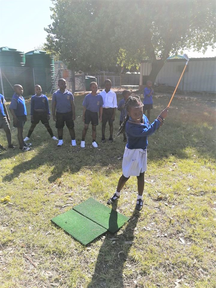 Girl playing golf in the South Africa Give back program